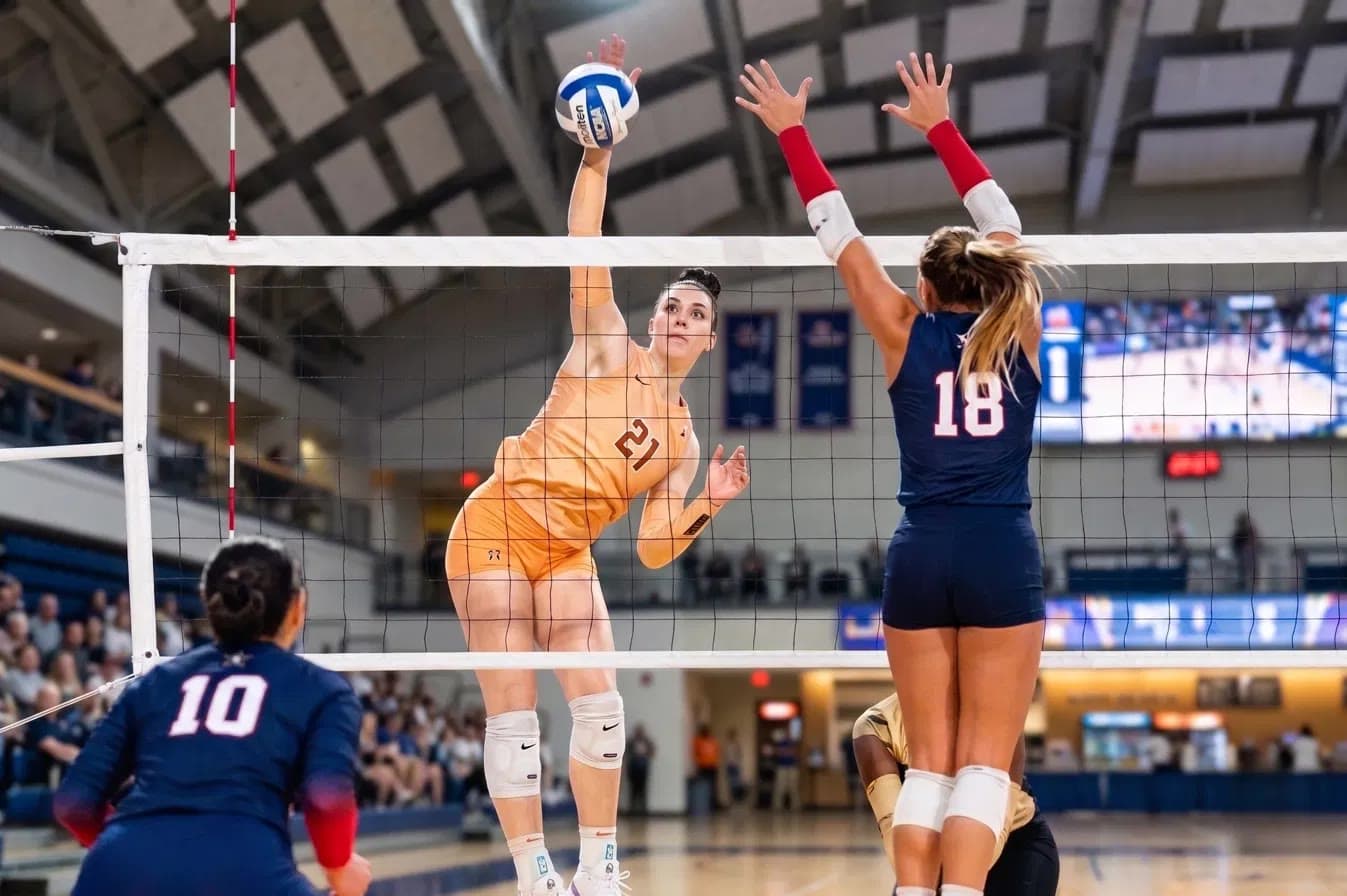 A volleyball player rising to spike at the net
